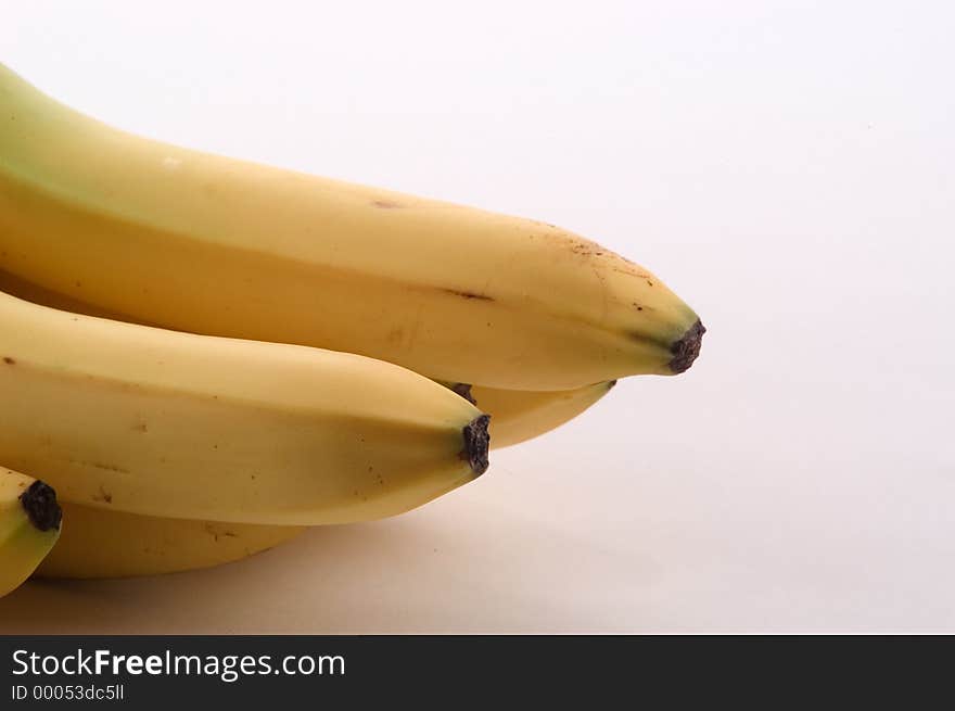 Banana ends photographed entering the image from the left edge. Photographed on a white background