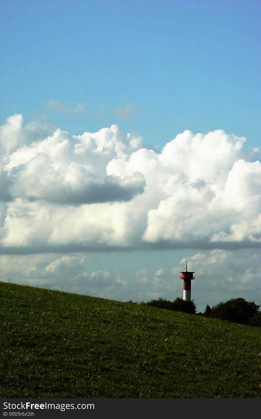 lighthouse behind a hill