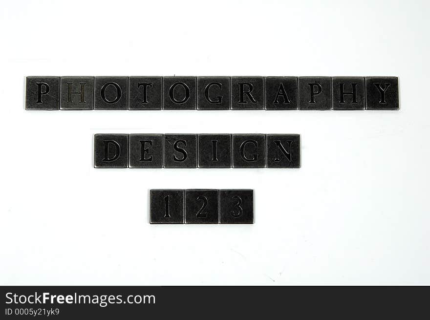 Photo of Square Metal Pieces With Letters Engraved in Them. The Words Photography and Design Are Spelled Out as Well as The Numbers 123. Individual Letters and Numbers Available on Request.