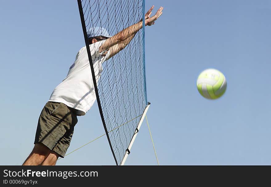 Young man hitting the ball over the net. Young man hitting the ball over the net