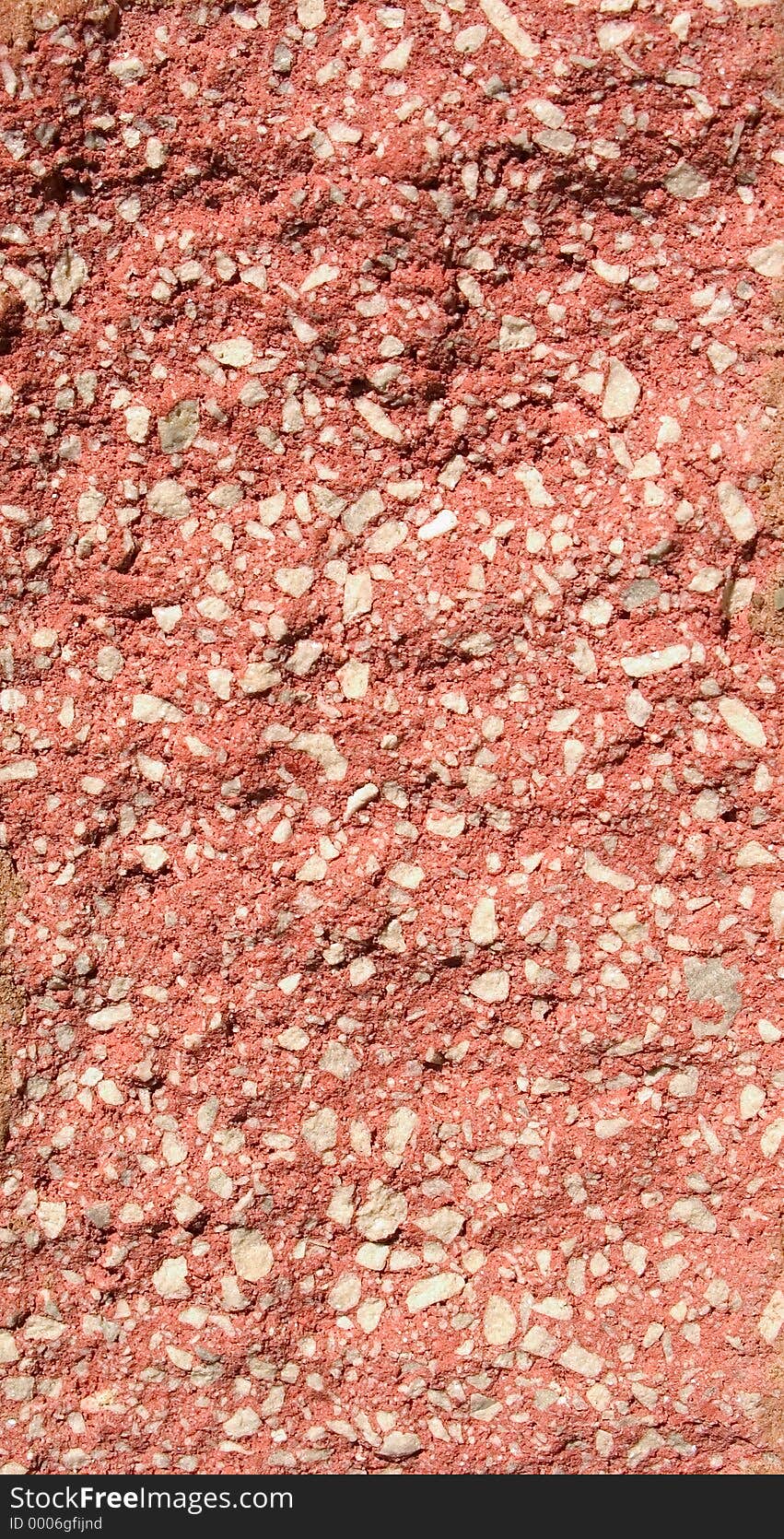 A section of a red stone block with white flecks in the block. Block has a rough texture. A section of a red stone block with white flecks in the block. Block has a rough texture.