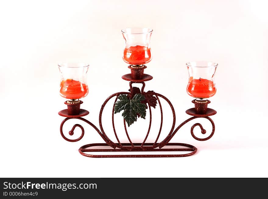 A pumkpin candle holder holds three votive cups and candles as a center piece. A pumkpin candle holder holds three votive cups and candles as a center piece.