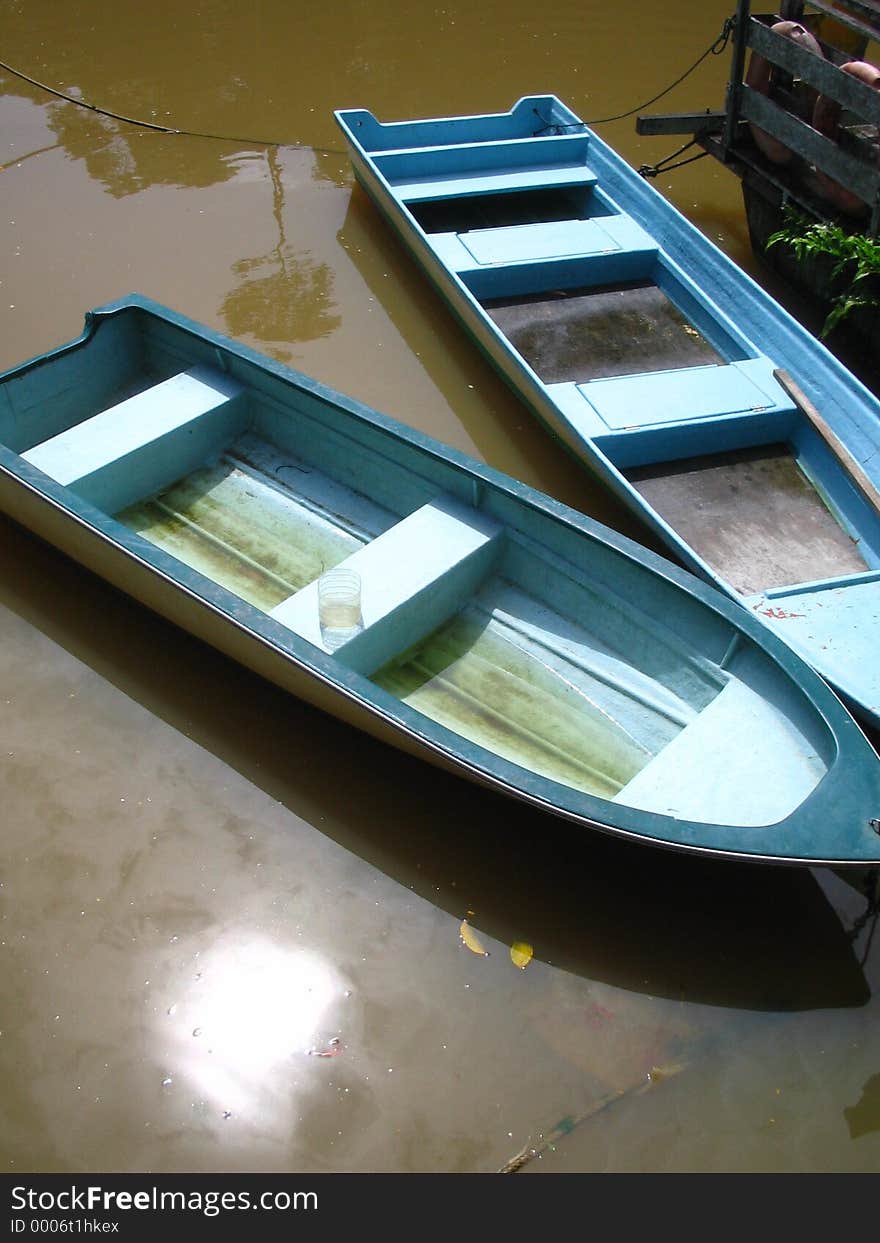 Two bright blue rowboats at a misty river in borneo, sarawak, malaysia. Two bright blue rowboats at a misty river in borneo, sarawak, malaysia