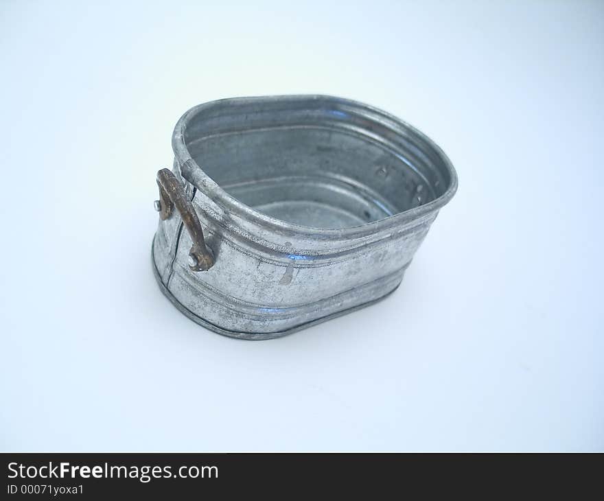 A miniature pail on a blue toned background. A miniature pail on a blue toned background.