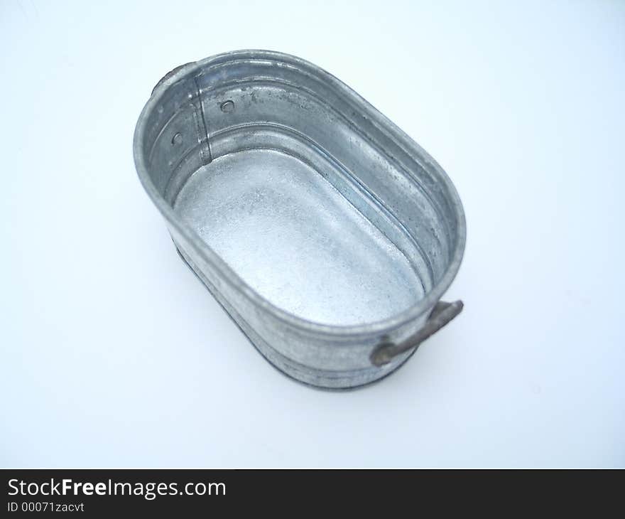 A miniature pail on a blue toned background. A miniature pail on a blue toned background.