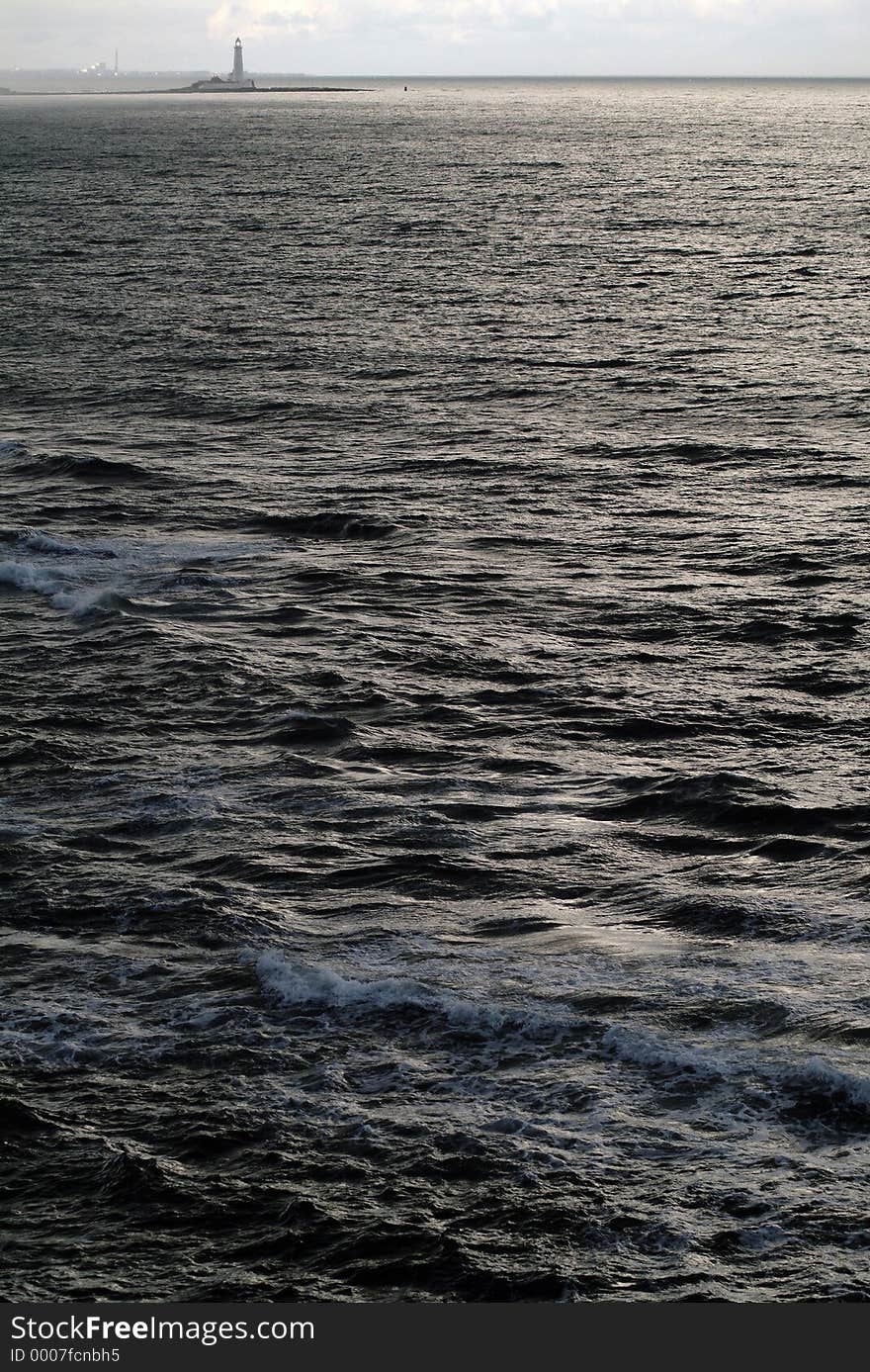 Lighthouse with fairly calm sea in foreground. Lighthouse with fairly calm sea in foreground.