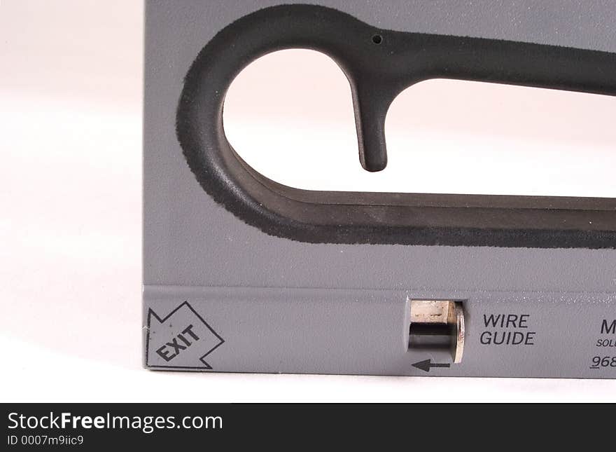 Detail of a power stapler showing the wire guide and part of the hand grip area. Detail of a power stapler showing the wire guide and part of the hand grip area.