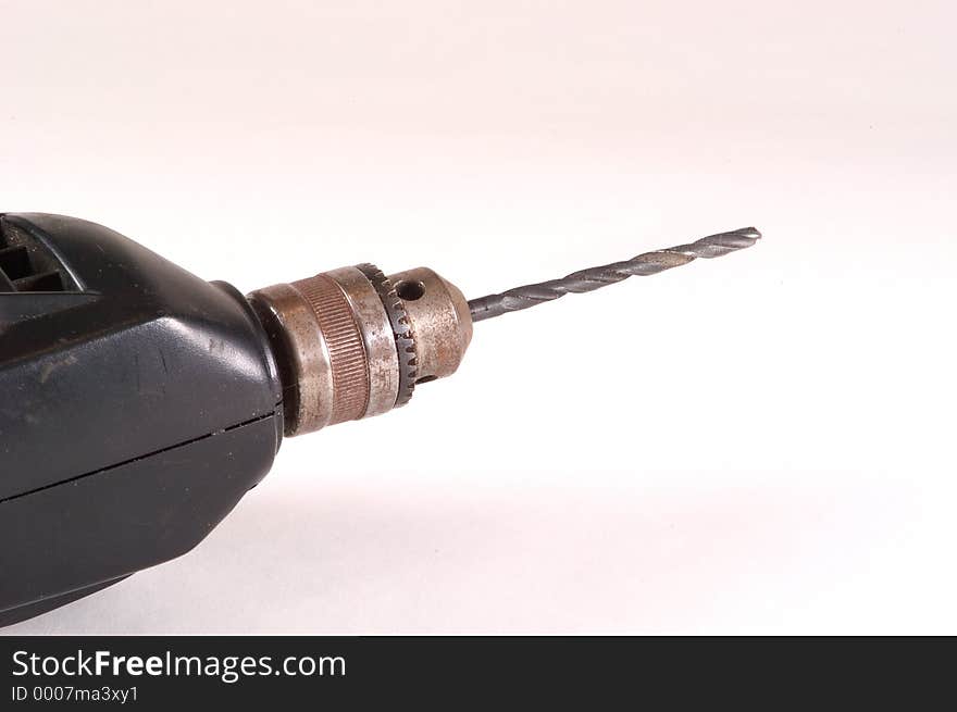 Detail of an electric drill showing the drill chuck and a bit. Photographed on a white background. Detail of an electric drill showing the drill chuck and a bit. Photographed on a white background