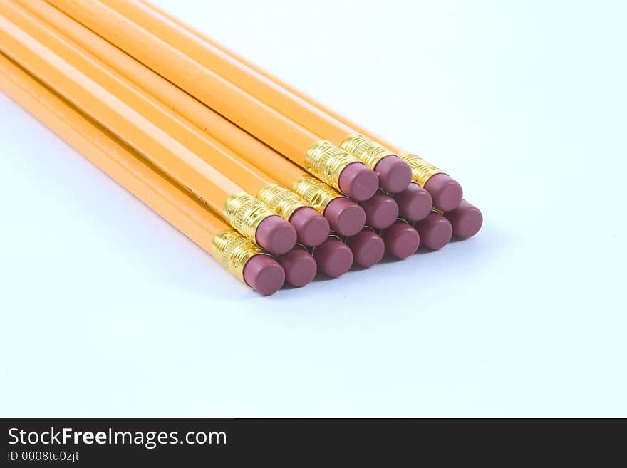 Several pencils stacked, eraser end yoward the camera, photographed on a white background. Several pencils stacked, eraser end yoward the camera, photographed on a white background