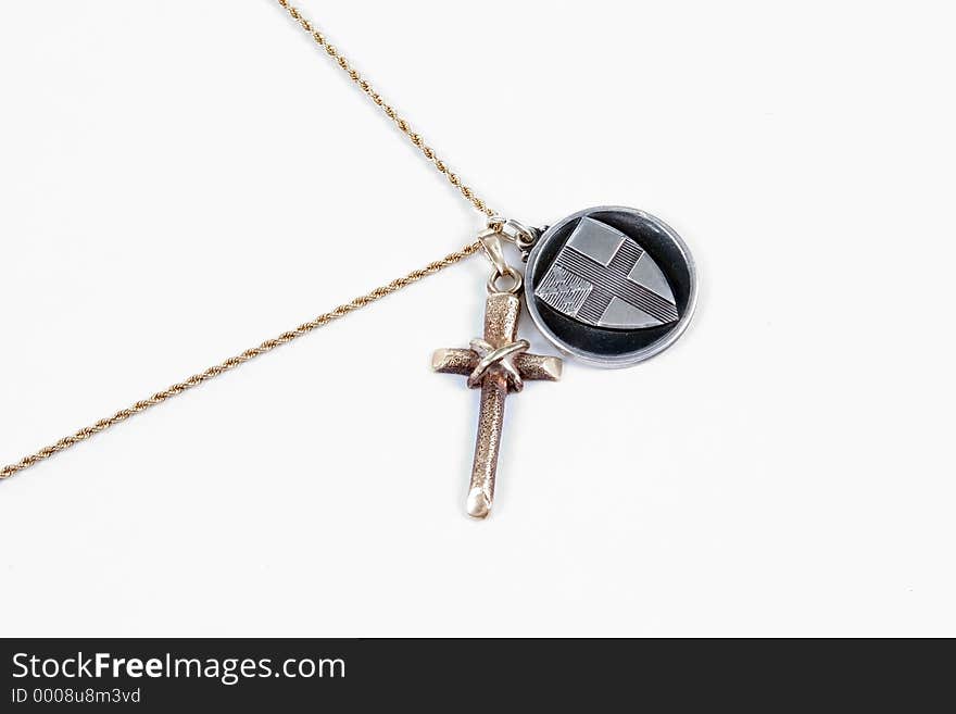 A gold cross and chain with a silver Episcopalian Medallion added. Photographed on a white background. A gold cross and chain with a silver Episcopalian Medallion added. Photographed on a white background