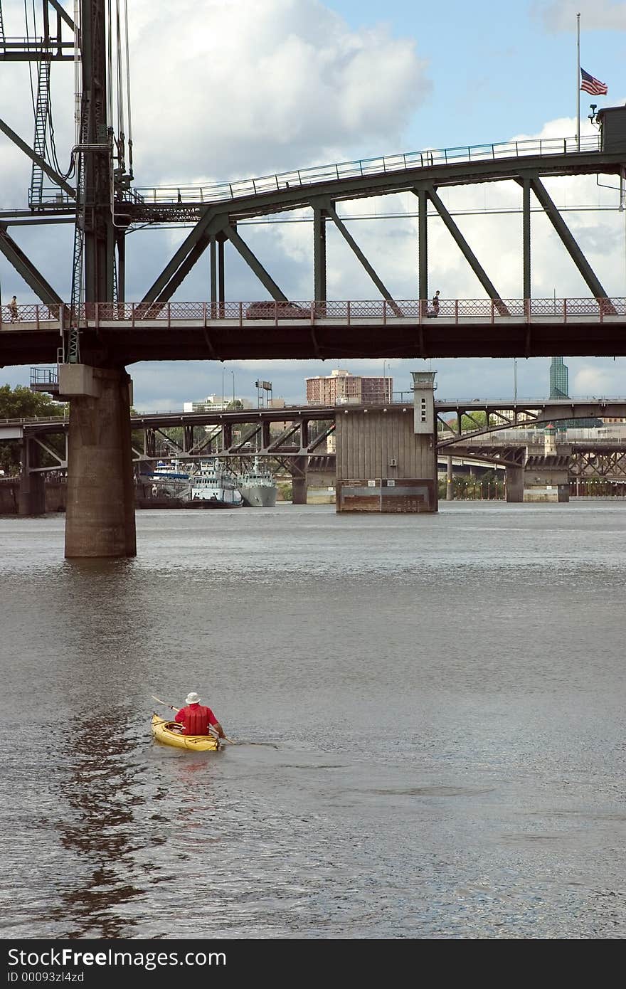 Man Kayaking under Bridges