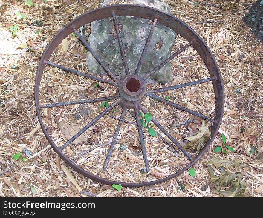 A soft image of a very old and rusty wheel from a wagon. A soft image of a very old and rusty wheel from a wagon.