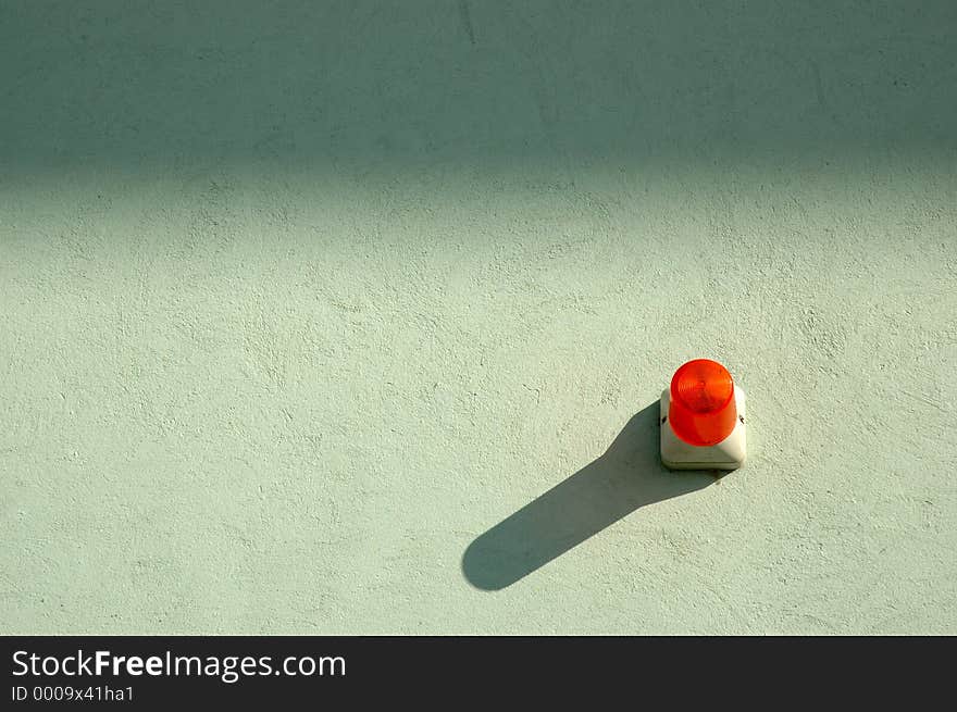 Alam light on plain wall casting a shadow. Alam light on plain wall casting a shadow