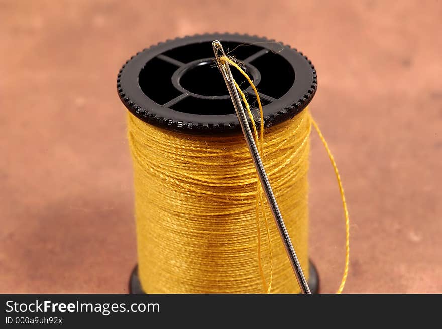 Photo of a Threaded Needle and Spool of Thread.