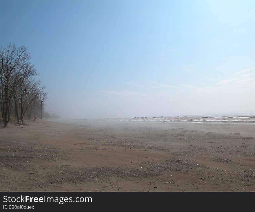 Vast landscape in gentle colors. The picture shows a hazy beach along Lake Eary in winter. Vast landscape in gentle colors. The picture shows a hazy beach along Lake Eary in winter