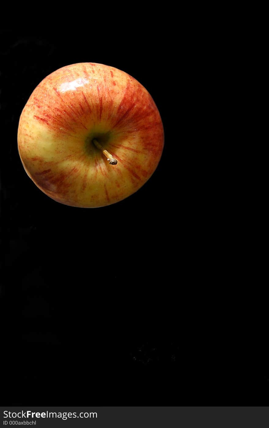 Top of a red yellow apple on a black background. Top of a red yellow apple on a black background