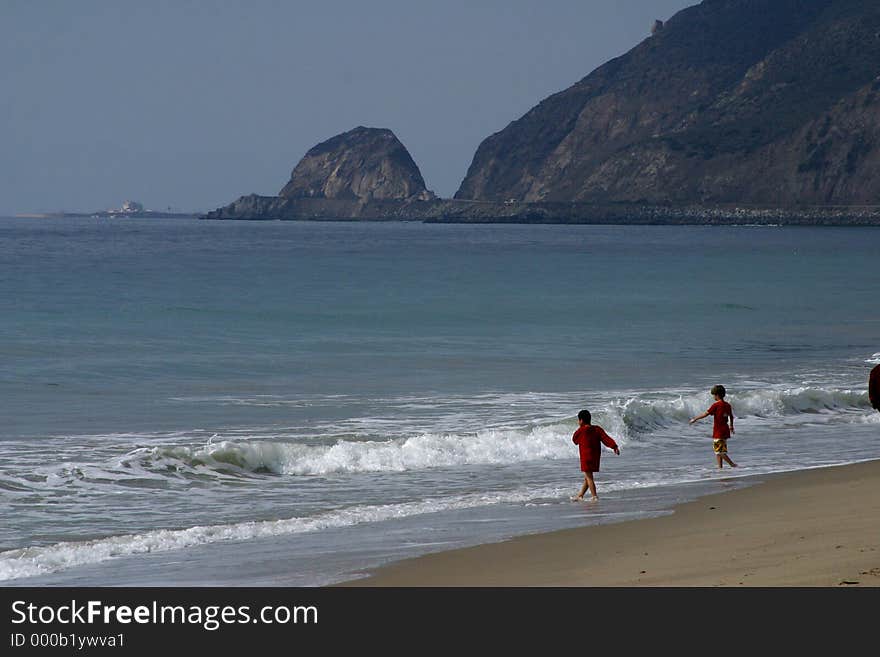 Kids playing on the beach, on the California coast.