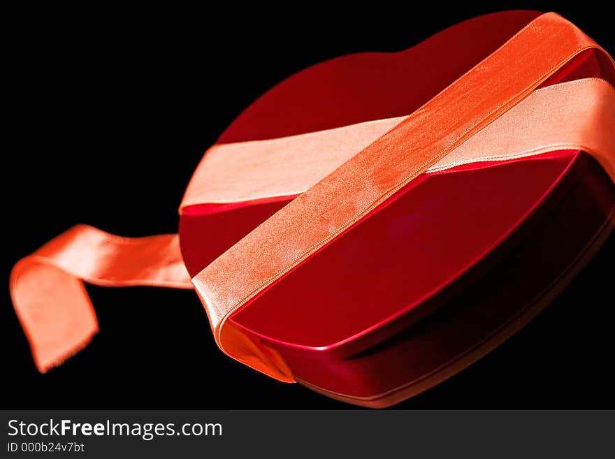 Heart shaped boxed wrapped with red ribbon. Heart shaped boxed wrapped with red ribbon