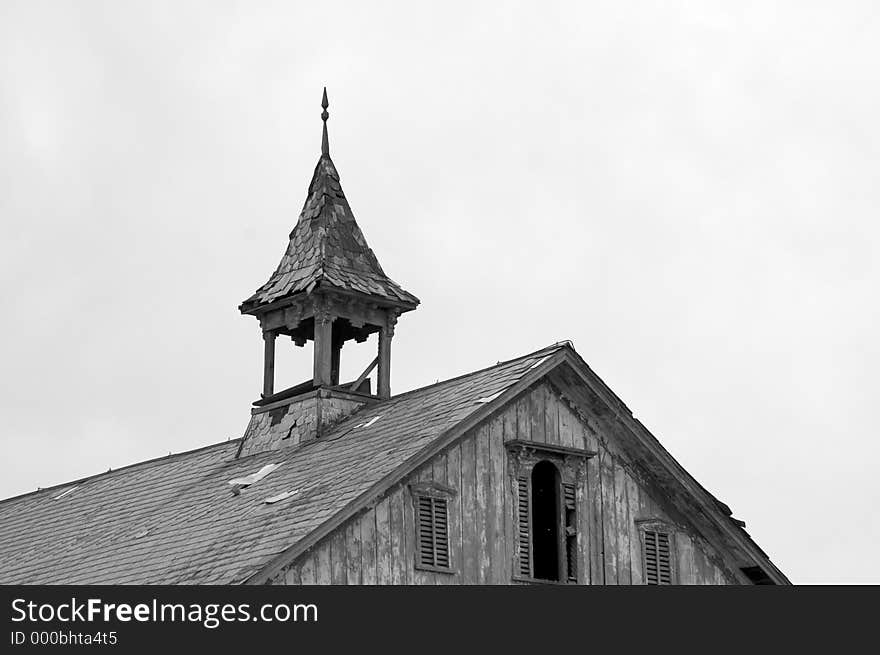 An old steeple on the roof of a barn shows the signs of age. Photographed in Black and White. An old steeple on the roof of a barn shows the signs of age. Photographed in Black and White