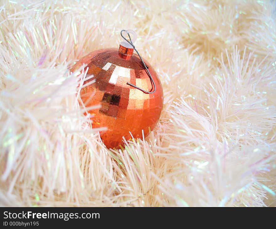 A shiny bulb sitting in a pile of garland. A shiny bulb sitting in a pile of garland.