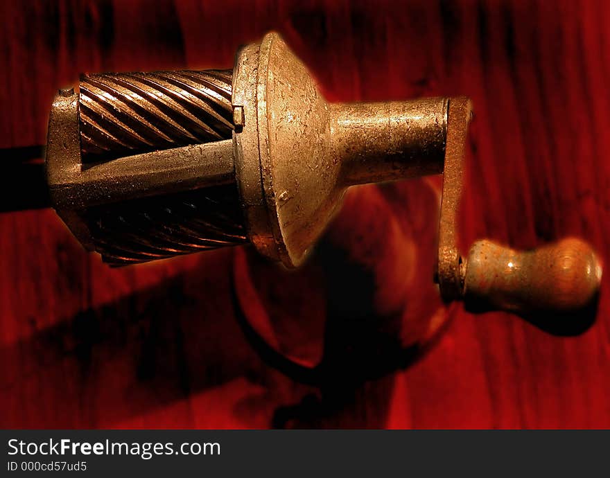 Old fashioned hand cranked pencil sharpener mounted on wood beam