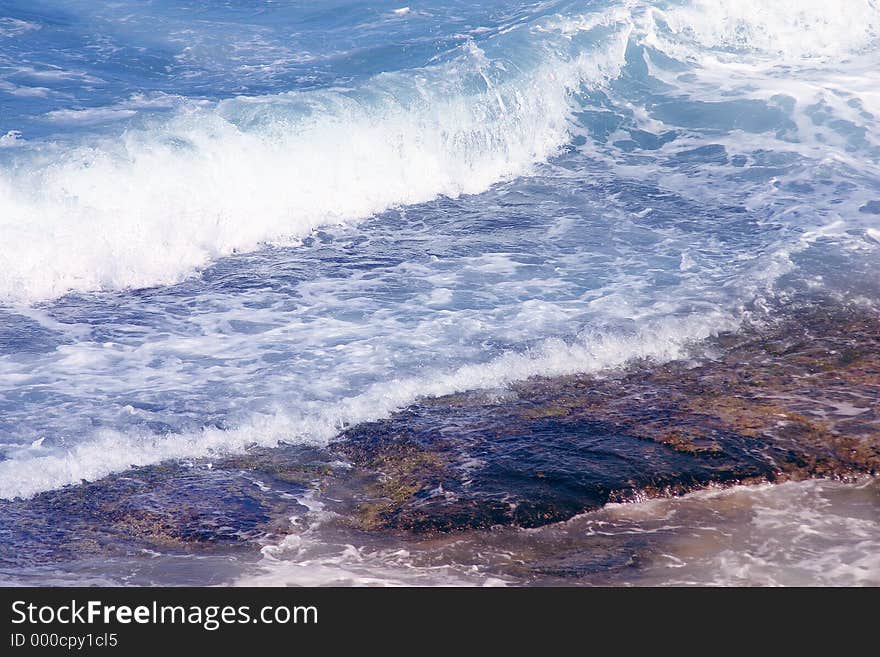 Blue water splashing over rocks. Blue water splashing over rocks