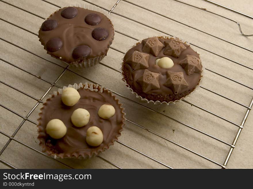 Three Chocolate Cupcakes cooling on a wire tray