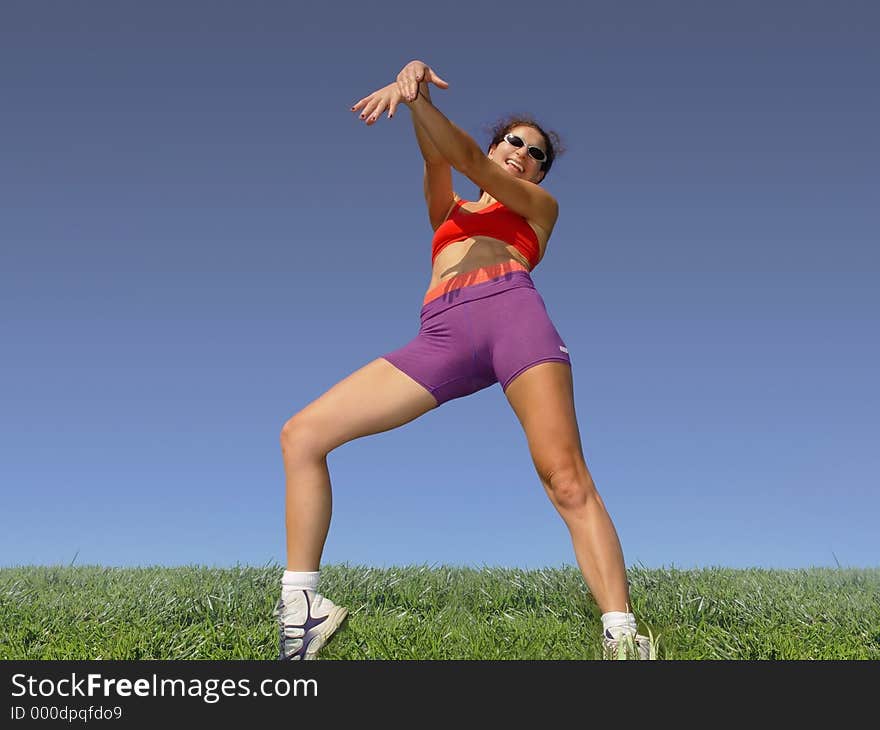 Girl exercising outdoors on the grass