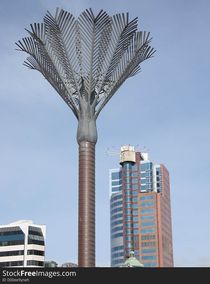 A large metal palm tree in Wellington's city square. Part of the skyline can be seen in the background.