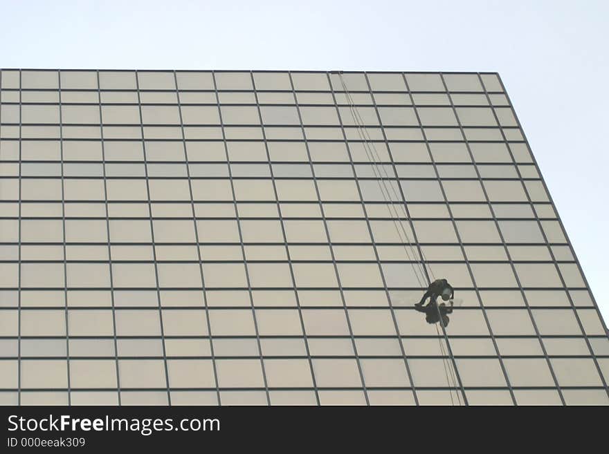 A window washer works high above the city streets.