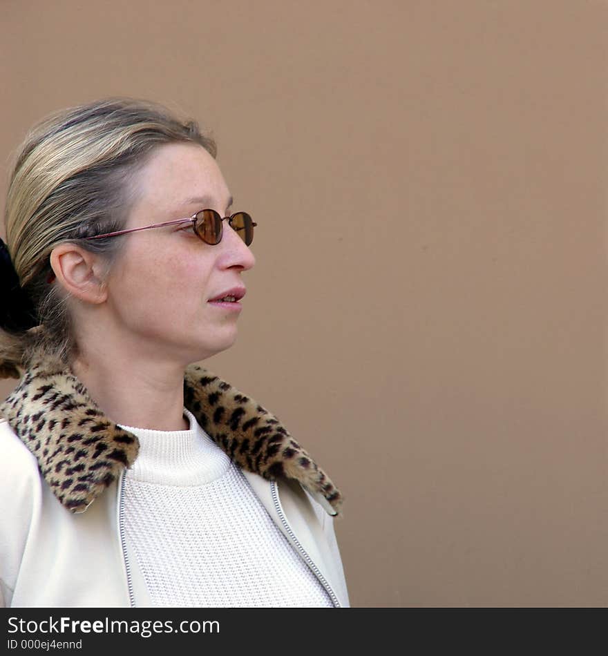 Blond woman in sunglaases in the corner with space for copy