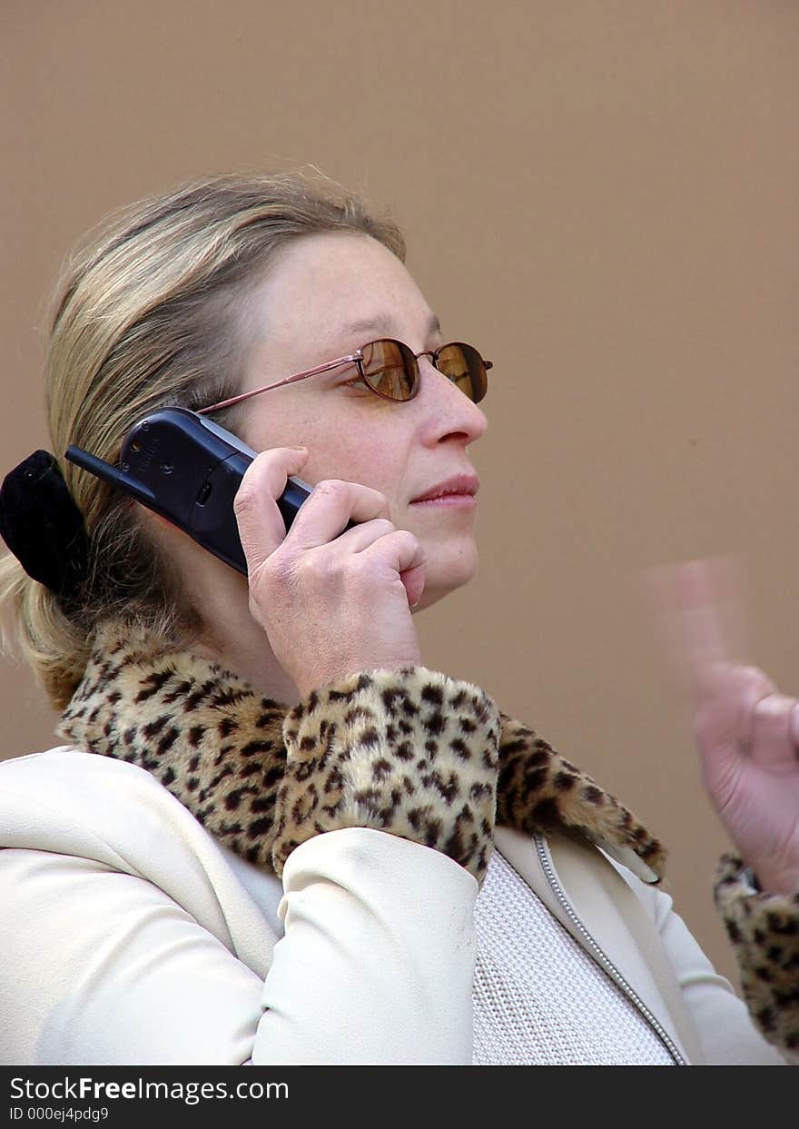 Woman talking on her cell phone. Left hand is blurred. Woman talking on her cell phone. Left hand is blurred