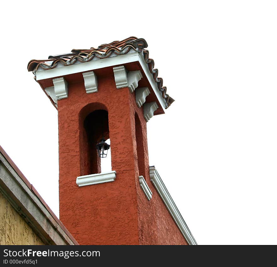 Details of tower with tile roof on terra cotta Spanish building, white trim, in the tropics