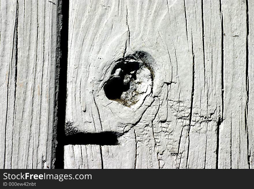 Painted wood surface in light grey showing knot in wood. Painted wood surface in light grey showing knot in wood