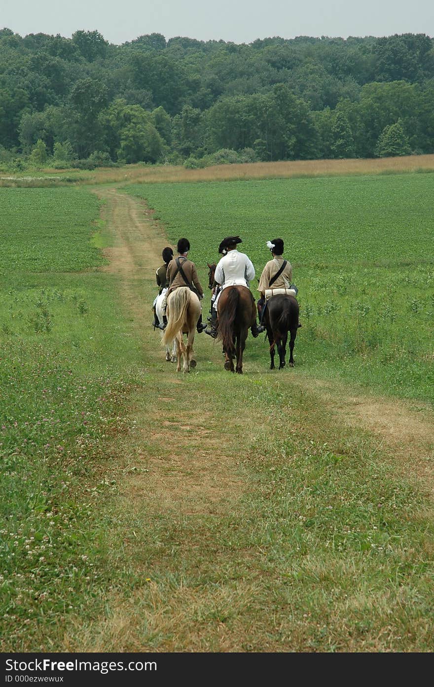 People on horses in independence revolutionary war costumers are riding away, going to perform a battle. People on horses in independence revolutionary war costumers are riding away, going to perform a battle