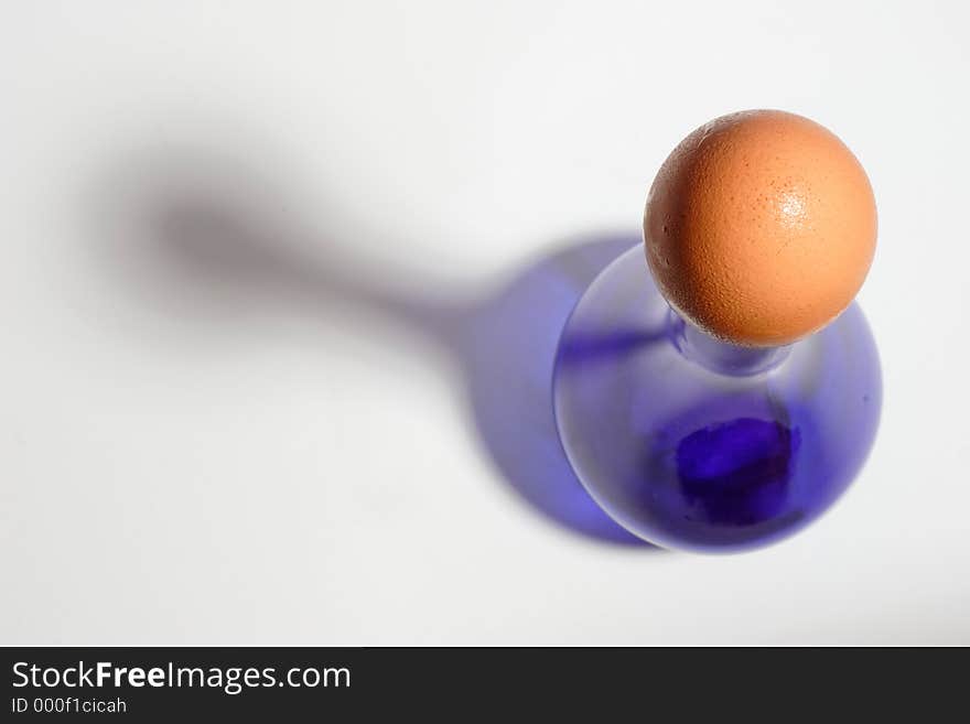 Brown egg capping a blue bottle. Brown egg capping a blue bottle