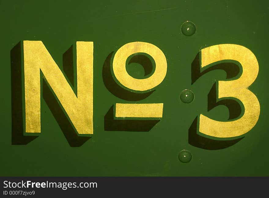 Hand painted gold on green 'No3' from the back of a steam engine.