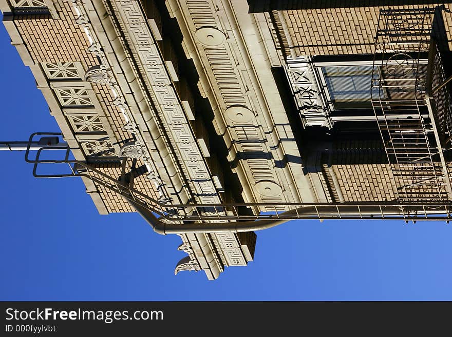 Corner of city building with blue sky in background