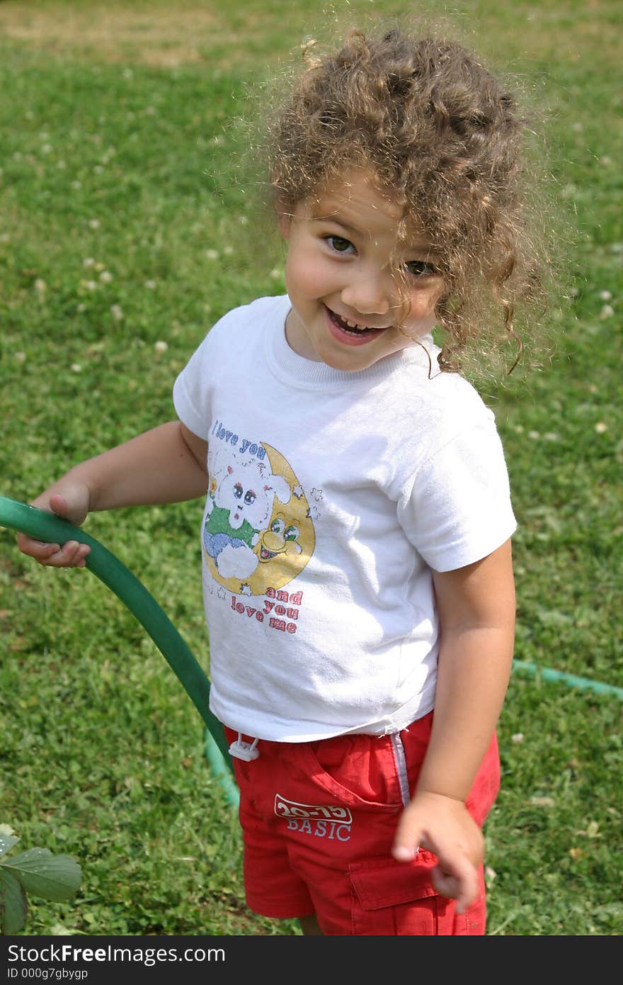 Little girl watering the garden. Little girl watering the garden