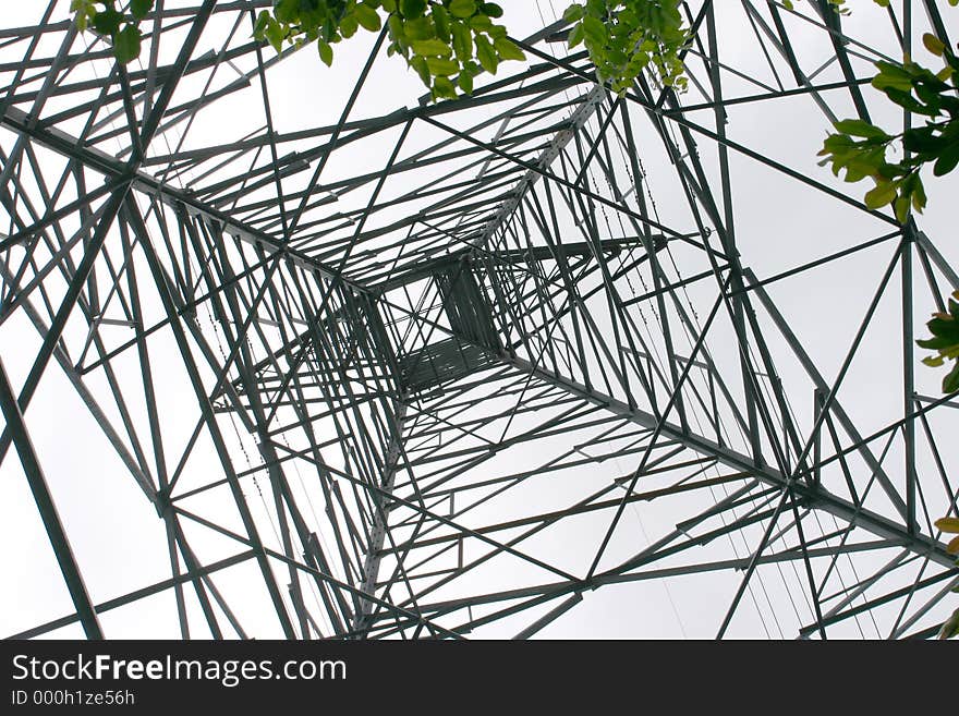 Looking up through the web of steel of a high voltage electricity tower. Looking up through the web of steel of a high voltage electricity tower