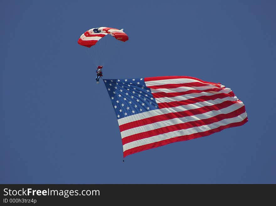 A skydiver coming down to earth with the American flag. A skydiver coming down to earth with the American flag.