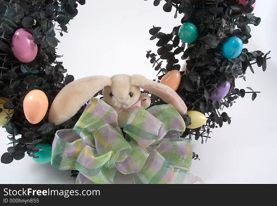 A wreath made of eucalyptis branches decorated for Easter with an Easter bunny, pastel bow and small Easter Eggs. A wreath made of eucalyptis branches decorated for Easter with an Easter bunny, pastel bow and small Easter Eggs