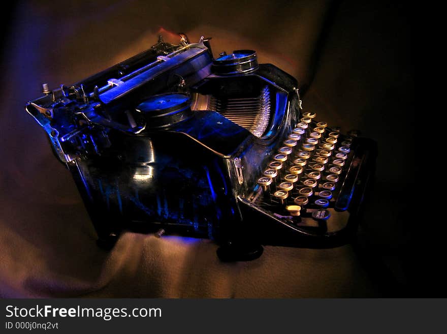 Antique black typewriter painted with UV light. Various objects on a dark background. Artistic blur. Antique black typewriter painted with UV light. Various objects on a dark background. Artistic blur.