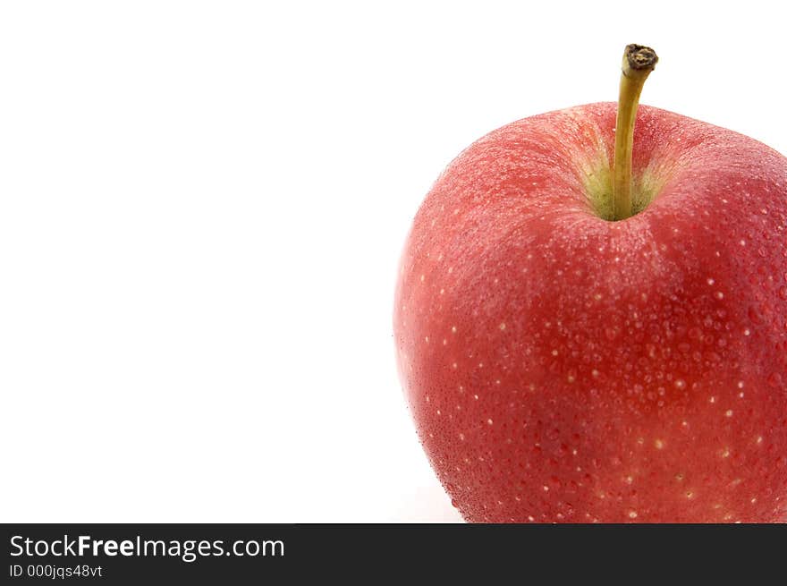 A red apple covered in water droplets. A red apple covered in water droplets