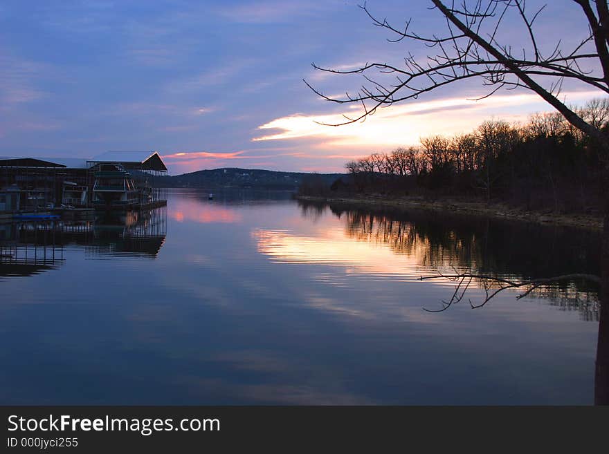 A different sunset photo with a boat dock, water, reflections, and just a little color in the sky. A different sunset photo with a boat dock, water, reflections, and just a little color in the sky