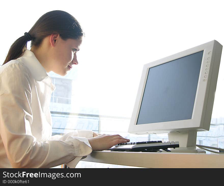 Young business woman working at a computer with a TFT screen. Young business woman working at a computer with a TFT screen.