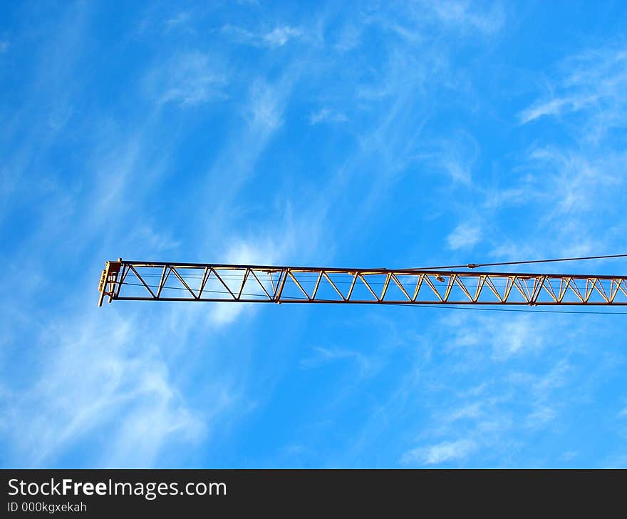 Typical industrial setting: crane's gibbet (jib) on blue sky. Typical industrial setting: crane's gibbet (jib) on blue sky