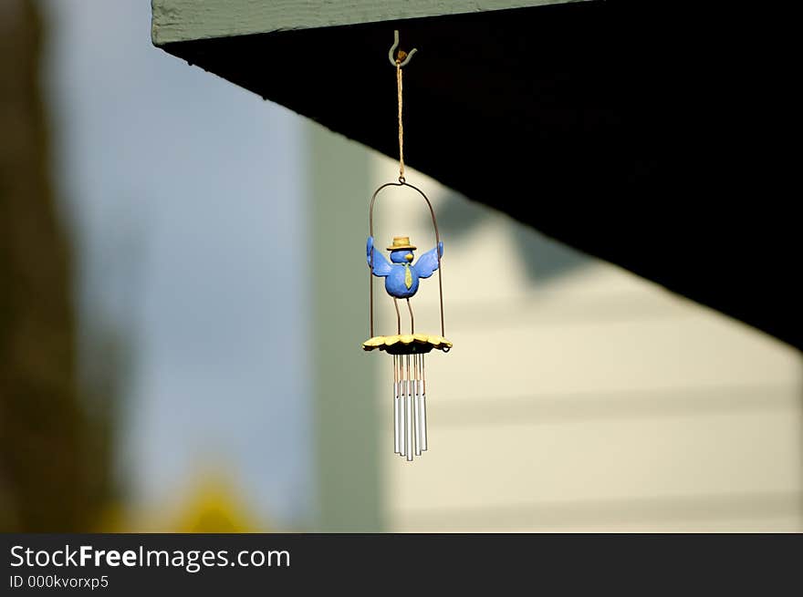 Clay bird hanging from patio roof.