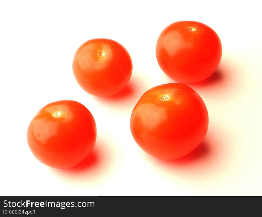 Four baby tomatoes over white