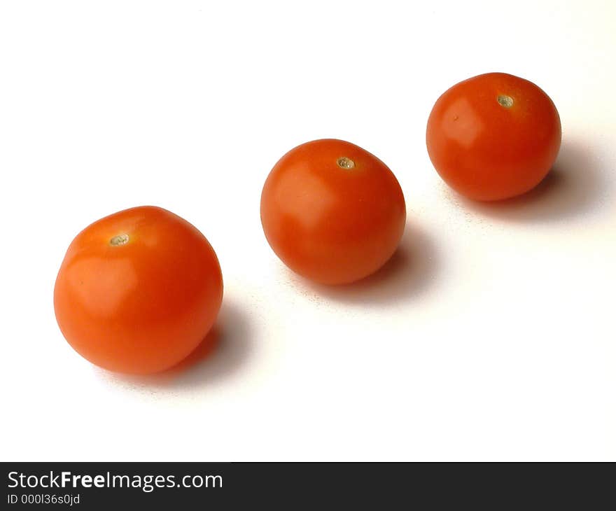 Three baby tomatoes in a diagonal row. Three baby tomatoes in a diagonal row